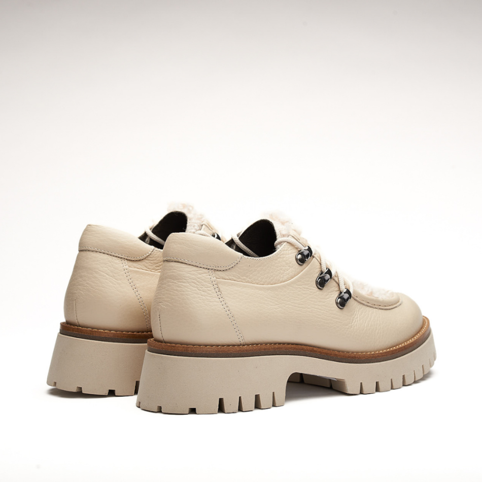 Shoe made entirely of leather and 4cm high sole. It is made from floty creme and its front is made from furry creme leather called mouton creme. It also has a small shoelace on the front and the eyelets are made of metal. The back is padded.