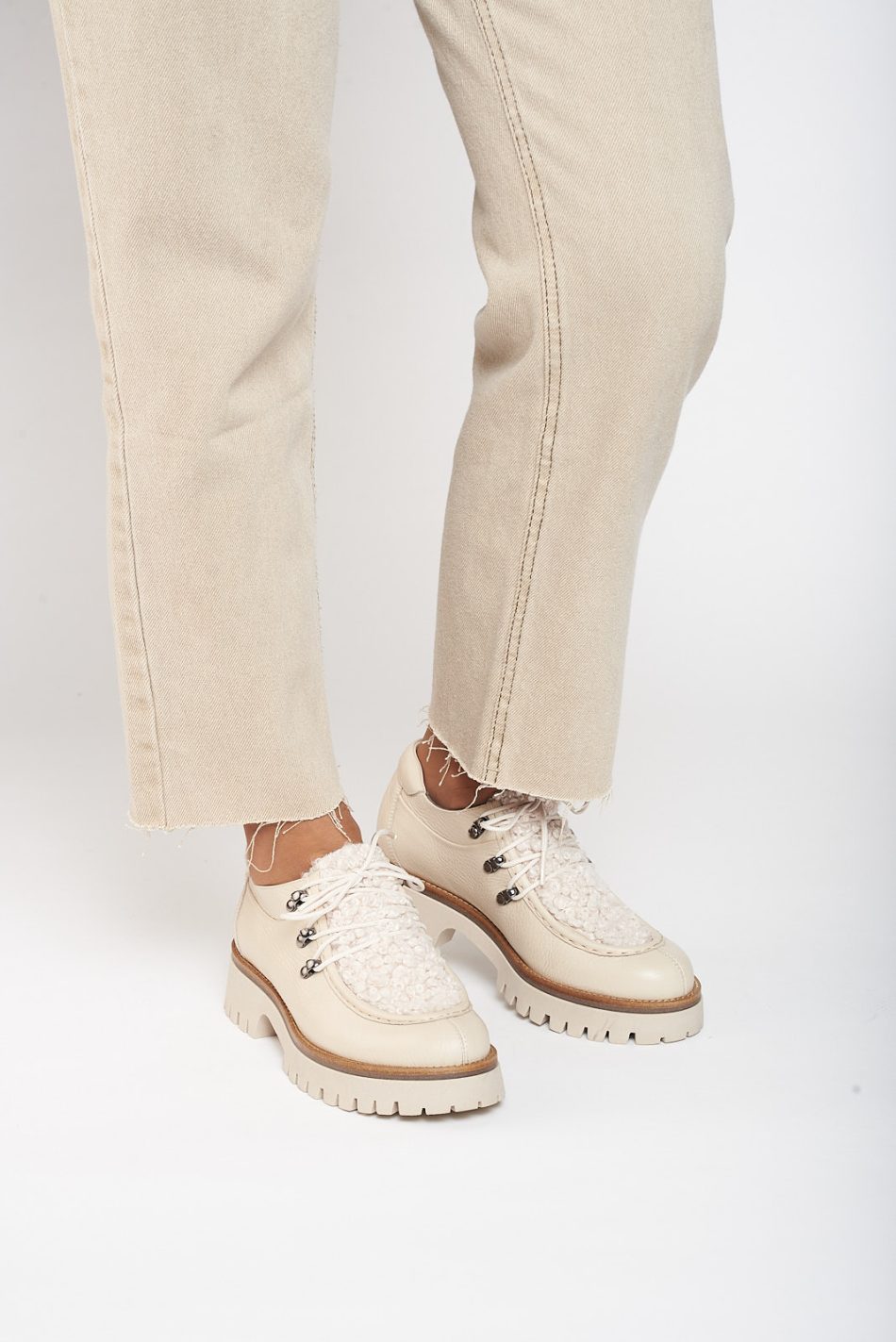 Shoe made entirely of leather and 4cm high sole. It is made from floty creme and its front is made from furry creme leather called mouton creme. It also has a small shoelace on the front and the eyelets are made of metal. The back is padded.