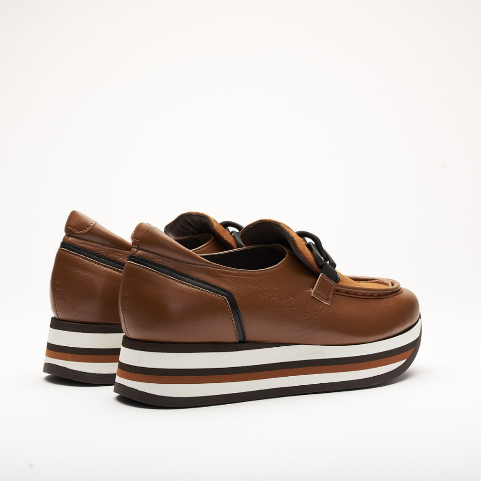 4cm platform shoe with white, black and cognac stripes made entirely of leather. It is made in Velour Cognac, Suprema Black and Suprema Cognac. It has a black application on the front of the shoe and the back is padded.