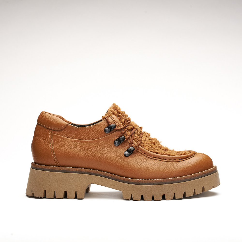 Shoe made entirely of leather and 4cm high sole. It is made from floty cognac and its front is made from furry cognac leather called mouton cognac. It also has a small shoelace on the front and the eyelets are made of metal. The back is padded.