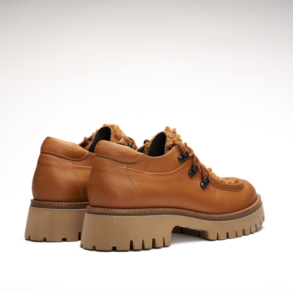 Shoe made entirely of leather and 4cm high sole. It is made from floty cognac and its front is made from furry cognac leather called mouton cognac. It also has a small shoelace on the front and the eyelets are made of metal. The back is padded.